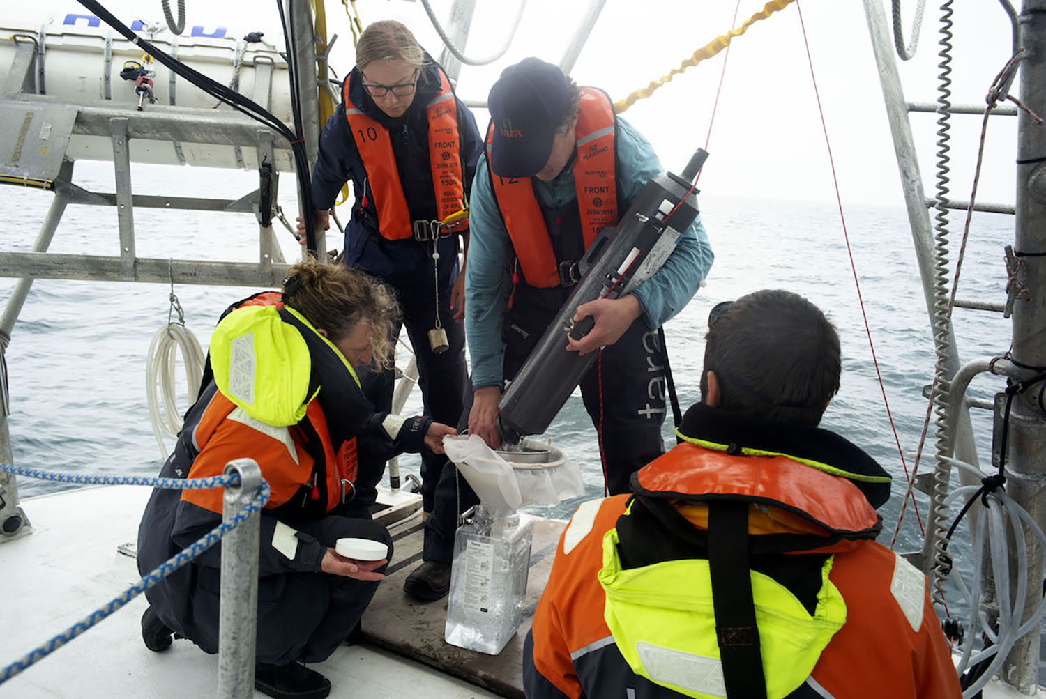 L’équipe scientifique à bord avec le niskin, un instrument de prélèvements de l’eau de mer à différentes profondeurs ©Samuel Bollendorff