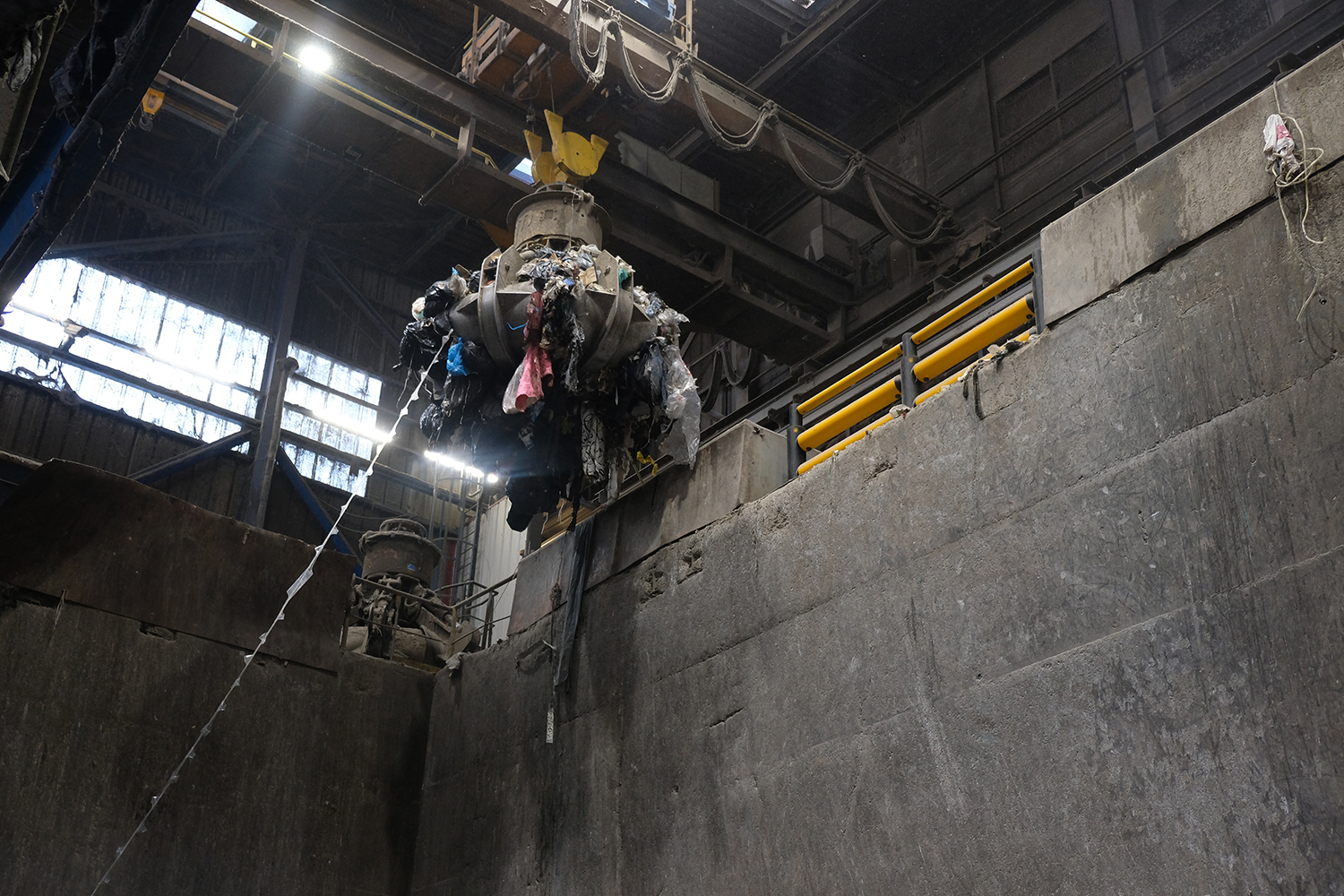 Une fois dans la fosse, une grosse pince métallique pilotée manuellement emporte les déchets vers l’incinérateur. 