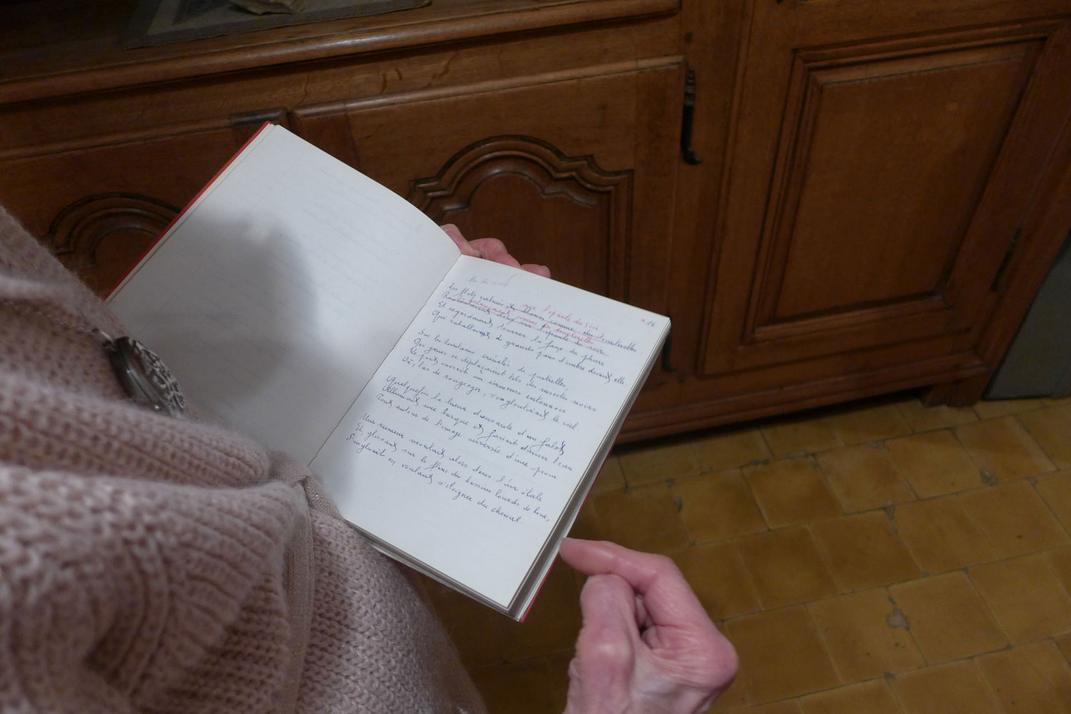 En 2019, Jeannine montre des poèmes manuscrits et corrigés. Elle a gardé des centaines de cahiers qui ont servi au poète © Globe Reporters
