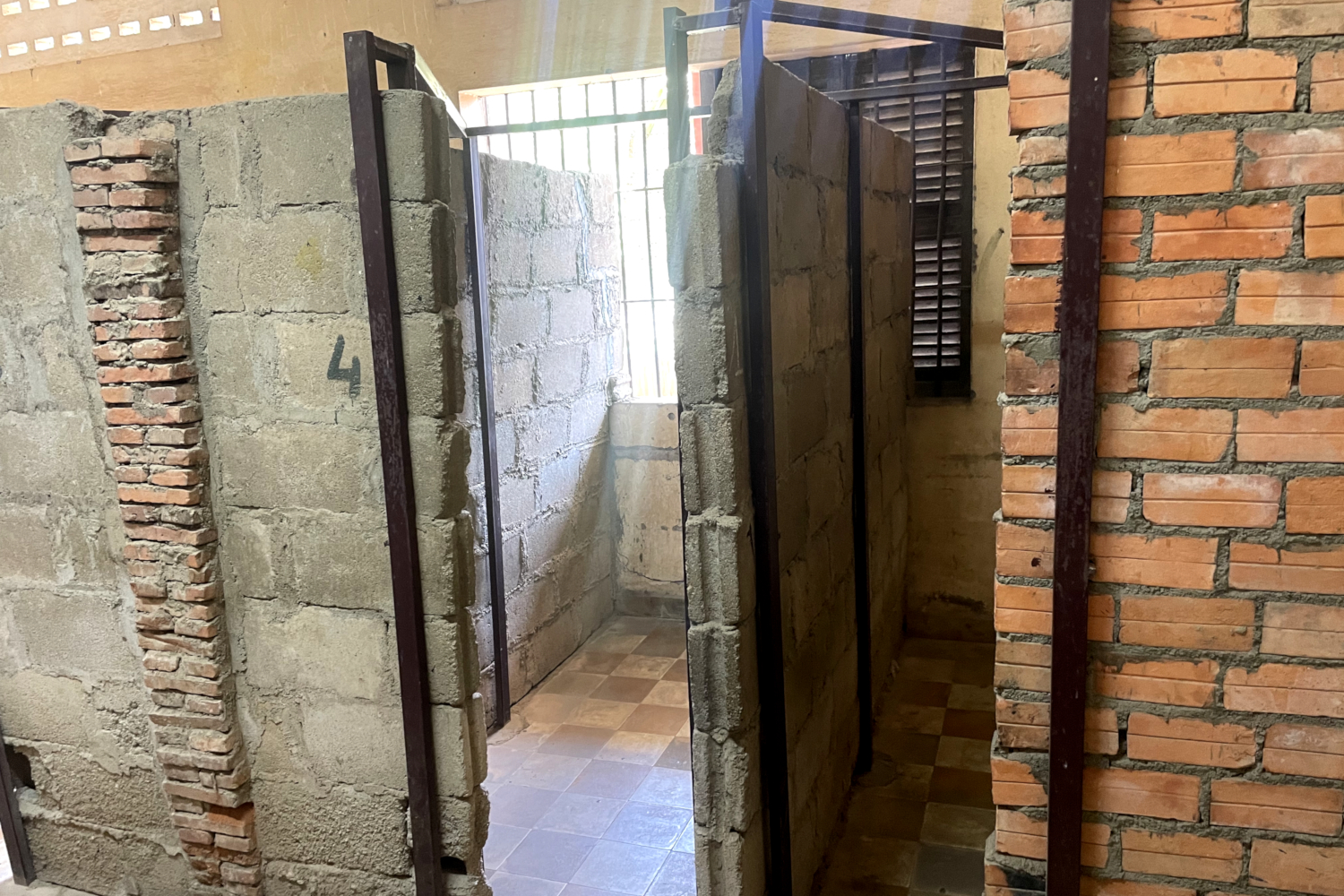 Cellules individuelles en parpaings construites à l’intérieur des anciennes salles de classe de la prison de Tuol Sleng (S21) © Globe Reporters