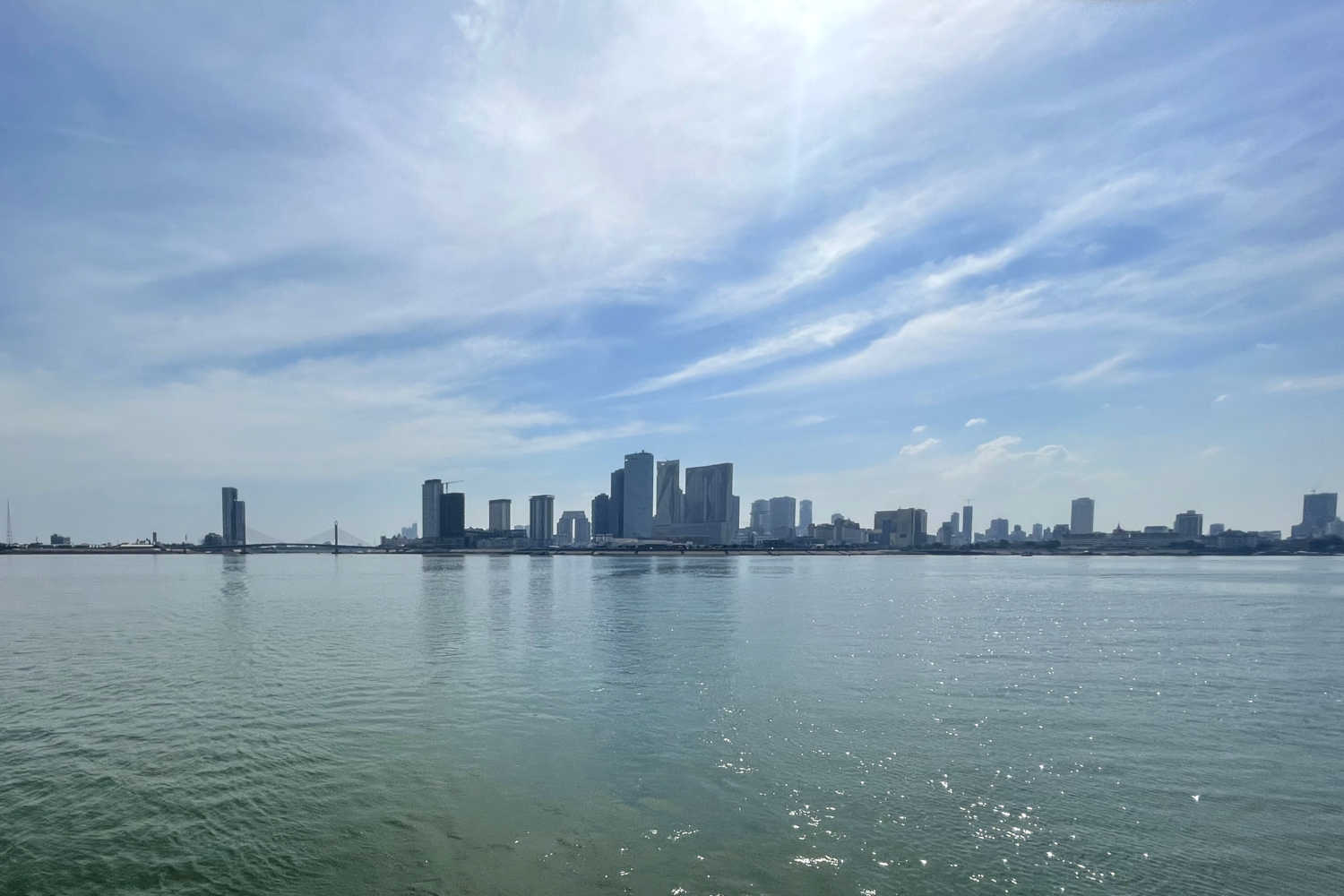 Les gratte-ciels de Phnom Penh et le Mékong vus depuis le bac qui arrive à Arey Ksart © Globe Reporters
