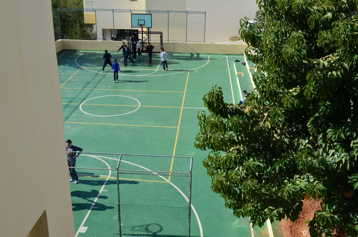 Terrain extérieur de basket et de football, entre le bâtiment du lycée et celui du collège © Racha KASSIR