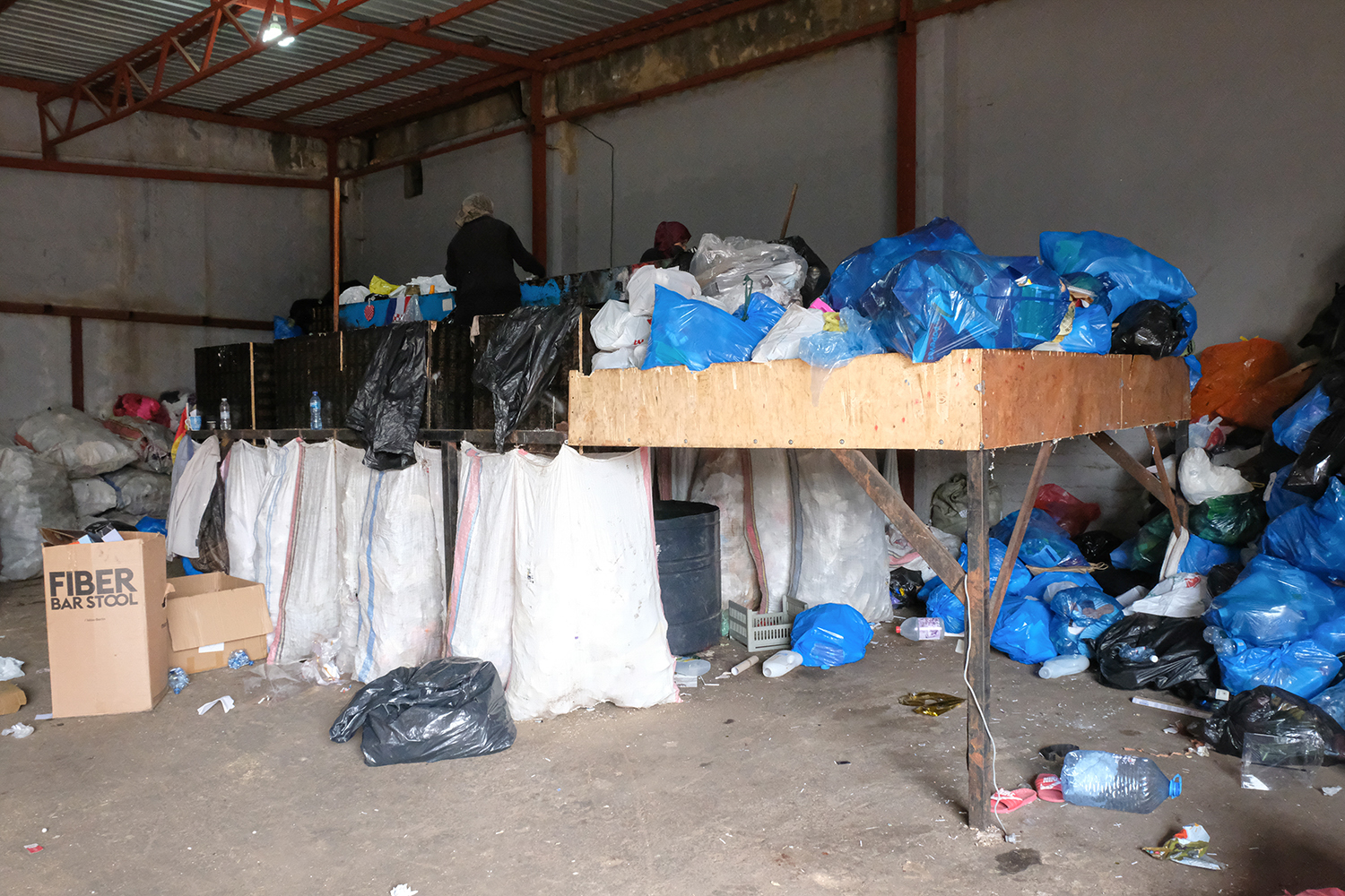 Les femmes s’occupent du tri des déchets sur cette table de tri en hauteur. Elles sont normalement trois, mais l’une d’entre elles est actuellement en Syrie pour quelques jours ©Globe Reporters